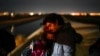 FILE - Cuban migrant Mario Perez holds his wife as they wait to be processed to seek asylum after crossing the border into the United States on Jan. 6, 2023, near Yuma, Ariz. 