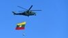 A Myanmar military helicopter carries the national flag over a parade ground to mark the country's Independence Day in Naypyidaw on Jan. 4, 2023.