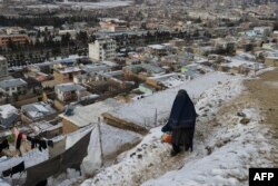 Seorang perempuan berjalan di jalan setapak saat musim dingin melanda kawasan Fayzabad, provinsi Badakhshan Afghanistan, 18 Januari 2023. (OMER ABRAR/AFP)