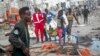 Rescuers remove a body from the scene of a double car bomb attack in Mogadishu, Somalia, Oct. 29, 2022.