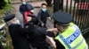 Aktivis prodemokrasi Hong Kong (tengah) tampak bergelut dengan staf Konsulat China di Manchester dalam aksi protes pada 16 Oktober 2022. (Foto: AFP/The Chaser News/Matthew Leung)