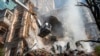Petugas pemadam kebakaran berusaha memadamkan kobaran api setelah serangan drone Rusia menghancurkan gedung-gedung di Kyiv, Ukraina, 17 Oktober 2022.