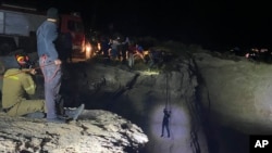 Authorities and local residents pull a migrant to safety after a sailboat carrying migrants sank near the island of Kythira, south of Athens, Greece, Oct. 6, 2022.