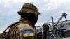 Seorang prajurit Ukraina berdiri di depan silo gandum di pelabuhan Laut Hitam Odesa, di Odesa, Ukraina, 29 Juli 2022. Pada 29 Oktober, Rusia mengakhiri kesepakatan yang ditengahi PBB yang memungkinkan Ukraina mengekspor gandum melalui laut. (Foto: Reuters)
