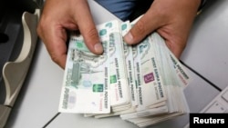 Seorang karyawan menghitung uang kertas rubel Rusia di kantor perusahaan swasta di Krasnoyarsk, Siberia, 17 Desember 2014. (Foto: Reuters)