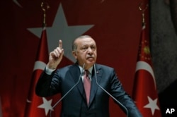 FILE - Turkey's President Recep Tayyip Erdogan talks to members of his ruling Justice and Development Party (AKP), in Ankara, Turkey, Oct. 26, 2018.