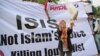 FILE - A Muslim woman releases a dove as a symbol of peace during a rally against the Islamic State group, in Jakarta, Indonesia.