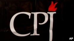 FILE - The Committee to Protect Journalists logo is seen on a banner at a media conference in Brussels, Belgium, Sept. 29, 2015. 