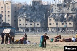 Palestinians carry their belongings following Israeli strikes on residential buildings at the Qatari-funded Hamad City in Khan Younis in the southern Gaza Strip on Dec.2, 2023.