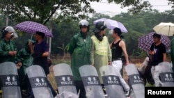 在杭州西郊的余杭镇，在一夜骚乱之后，防暴警察在余杭镇入口处把守（2014年5月11日）