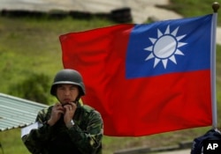 資料照：台灣旗幟前一名士兵整理自己的頭盔。