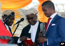 The Patriotic Front's Edgar Lungu, right, is sworn in as president at an inauguration ceremony in Lusaka, Jan. 25, 2015.