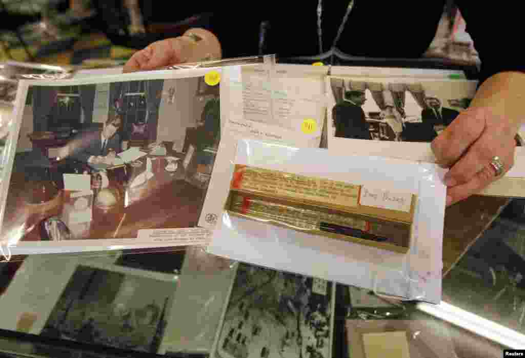 A pen used by the former U.S. President John F. Kennedy at the signing of the "Interdiction of the Delivery of Offensive Weapons to Cuba" next to a photo of the signing are displayed as part of the McInnis Auctioneers Presidential Auction in Amesbury, Massachussets.
