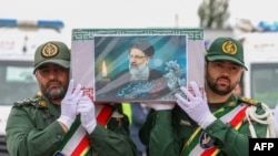 Pasukan penjaga kehormatan membawa peti mati mendiang presiden Ebrahim Raisi saat prosesi pemakaman mendiang presiden tersebut dan tujuh orang lainnya yang tewas dalam kecelakaan helikopter, di Tabriz, ibu kota Azerbaijan, Timur Iran, 21 Mei 2024. (Kepresidenan Iran / AFP)