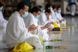 Sejumlah jamaah haji berdoa dalam ritual pertama haji dengan menjaga jarak sosial untuk membatasi paparan dan potensi transmisi virus Covid-19, di Masjidil Haram, Mekkah, Arab Saudi, Rabu, 29 Juli 2020. (Saudi Media Ministry via AP)