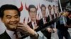 FILE - A protester raises a poster depicting outgoing Chief Executive Leung Chun-ying, left, with devil horns during a rally on the first day of 2017 in Hong Kong, Jan. 1, 2017.