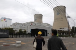 Para pejalan kaki melintas di depan PLTU batu bara milik China Energy di Shenyang, Provinsi Liaoning, China, September 2021.