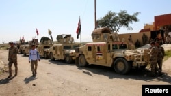 Military vehicles of Iraqi security forces and Shi'ite fighters are seen as they gather at Udhaim dam, north of Baghdad, March 1, 2015. 
