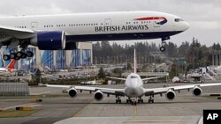 FILE - A British Airways jet flies overhead on landing in Everett, Washington. 