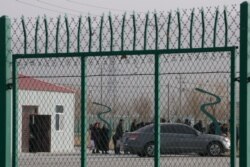 FILE - In this Dec. 3, 2018, residents line up inside the Artux City training center in western China's Xinjiang region. A U.S. envoy on religion has described China’s internment of 1 million Muslims as a “horrific situation.”