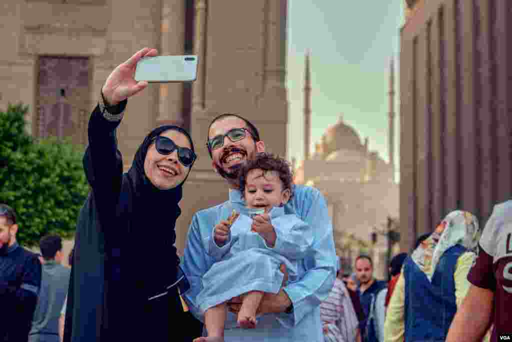 This family is taking a selfie in front of a complex of ancient mosques in Old Cairo, after prayers. (H. Elrasam/VOA)