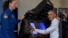 President Barack Obama sits in a flight simulator during a tour of innovation projects at the White House Frontiers Conference at University of Pittsburgh in Pittsburgh, Oct. 13, 2016, as NASA astronaut Dr. Serena Aunon-Chancellor watches.