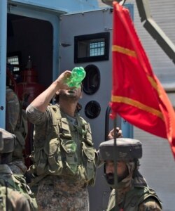 An Indian soldier drinks water as they return from the site of a gun-battle in Srinagar, Indian controlled Kashmir, Sunday, June 21, 2020.