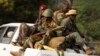 Former Seleka soldiers sit at the back of a truck during an operation of transferring all former Seleka soldiers from their main base to a smaller base north of the capital, Bangui, January 27, 2014. 