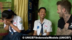 David Beckham tertawa dengan Sripun (kiri) dan Ego, teman baiknya, di rumah nenek Ego di Semarang.