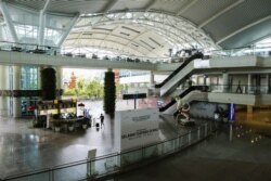 Seorang pelawat berjalan menyusuri terminal kedatangan internasional yang hampir kosong dari bandara Gusti Ngurah Rai di tengah penyebaran Covid-19 di Bali, 1 April 2020. (Foto: REUTERS/Johannes P. Christo)