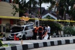 Polisi memeriksa mobil yang digunakan penyerang di luar Mapolres Pekanbaru, Riau, menyusul penyerangan pada 16 Mei 2018. (Foto: AFP/Dedy Sutisna)