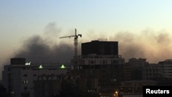 Smoke rises over central Khartoum as cars burn during demonstrations over the deaths of four students from war-torn Darfur, December 9, 2012.
