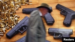 A man walks by the Glock handgun billboard at the 132nd Annual National Rifle Association Meeting in in Orlando, Florida April 27, 2003. The NRA has a membership of approximately 4 million and the annual event brings thousands to the meetings.
