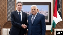 Presiden Otoritas Palestina Mahmud Abbas (kanan) dan Menteri Luar Negeri AS Antony Blinken berjabat tangan di awal pertemuan yang digelar di Muqata, kompleks kepresidenan di Ramallah, Tepi Barat, pada 30 November 2023. (Foto: Saul Loeb/Pool/AFP)
