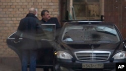 FILE - Former Russian defense minister Anatoly Serdyukov (R) is seen getting into a car in Moscow, Russia, Dec. 6, 2013. Spanish prosecutors suspect Serdyukov of having ties to the criminal underworld.
