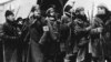FILE - In a 1965 image provided by MGM, Yuri Zhivago, played by Omar Sharif (2nd from L), is shown arriving with replacement Russian troops in a scene from the film 'Doctor Zhivago.'