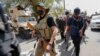 Sejumlah pengikut dari Ulama Irak Muqtada al-Sadr berjalan meninggalkan lokasi unjuk rasa setelah bentrokan terjadi di dekat Zona Hijau Baghdad, pada 30 Agustus 2022. (Foto: Reuters/Ahmed Saad)