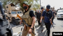 Sejumlah pengikut dari Ulama Irak Muqtada al-Sadr berjalan meninggalkan lokasi unjuk rasa setelah bentrokan terjadi di dekat Zona Hijau Baghdad, pada 30 Agustus 2022. (Foto: Reuters/Ahmed Saad)