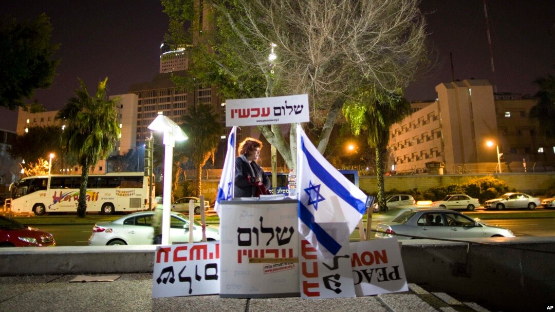 FILE - An Israeli peace activist hands out signs prior to a protest in Tel Aviv, Israel, Jan. 15, 2011. A newly-proposed Israeli law would require nonprofit groups to disclose foreign sources of funding.