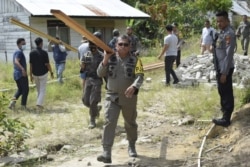 Kapolda Sulawesi Tengah Irjen Pol Abdul Rakhman Baso memikul balok kayu yang akan digunakan dalam pembangunan kembali rumah warga yang sebelumnya dibakar kelompok teroris MIT, Kamis , 3 Desember 2020. (Foto : Humas Polda Polda Sulawesi Tengah)