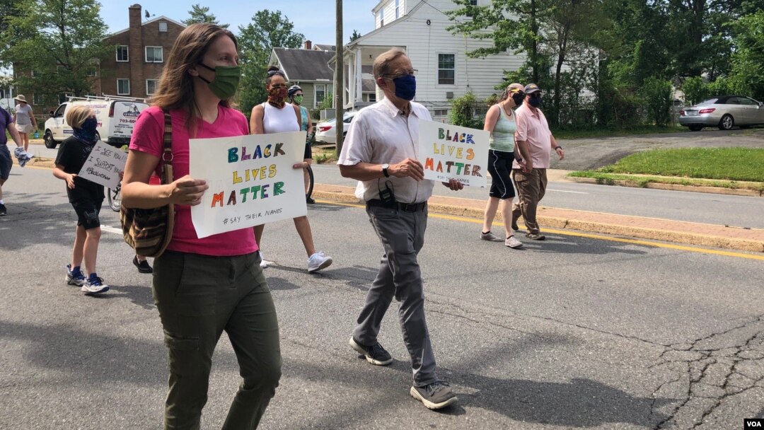 Julia Young, marching with her father Malcolm, in an Arlington, Virginia, “Say Their Names” protest against police brutality. (VOA/Carolyn Presutti)