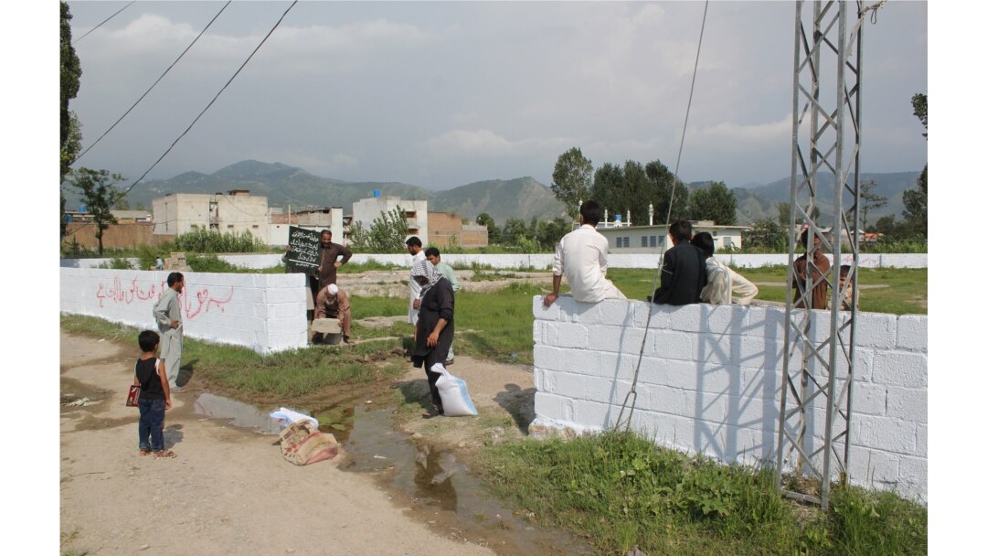 FILE - Pakistani workers mark the edges of the patch of ground where the house where Al-Qaeda leader Osama Bin Laden was killed once stood in Abbottabad on July 23, 2016.