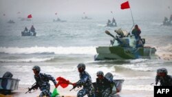 资料照：中国解放军两栖坦克与士兵参加在山东举行的登陆军演。（2005年8月24日）
