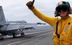 FILE - A U.S. fighter jet takes off from the U.S. aircraft carrier USS Ronald Reagan for their patrol in the international waters near the South China Sea, Aug. 6, 2019.