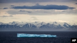 FILE - An iceberg floats past Bylot Island in the Canadian Arctic Archipelago, July 24, 2017.