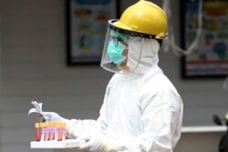 Seorang petugas kesehatan membawa sampel darah saat tes cepat virus corona di sebuah rumah sakit di Jakarta, 28 April 2020. (Foto: AP)