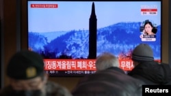 27일 한국 서울 시민들이 지하철역 TV를 통해 북한 탄도미사일 발사 뉴스를 시청하고 있다. 