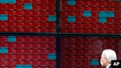 A man looks at an electronic stock board showing Japan's Nikkei 225 index at a securities firm in Tokyo, May 11, 2020. 