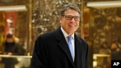 Mantan gubernur Texas Rick Perry tersenyum saat meninggalkan Trump Tower, di New York, 12 Desember 2016 (AP Photo/Kathy Willens).