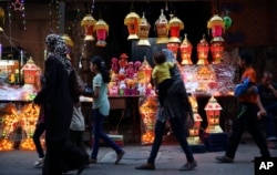 Warga Palestina berjalan di depan lampu-lampu khas Ramadan yang dinyalakan, menandai bulan suci Ramadan di pasar di kota Gaza, 3 Juni 2016.